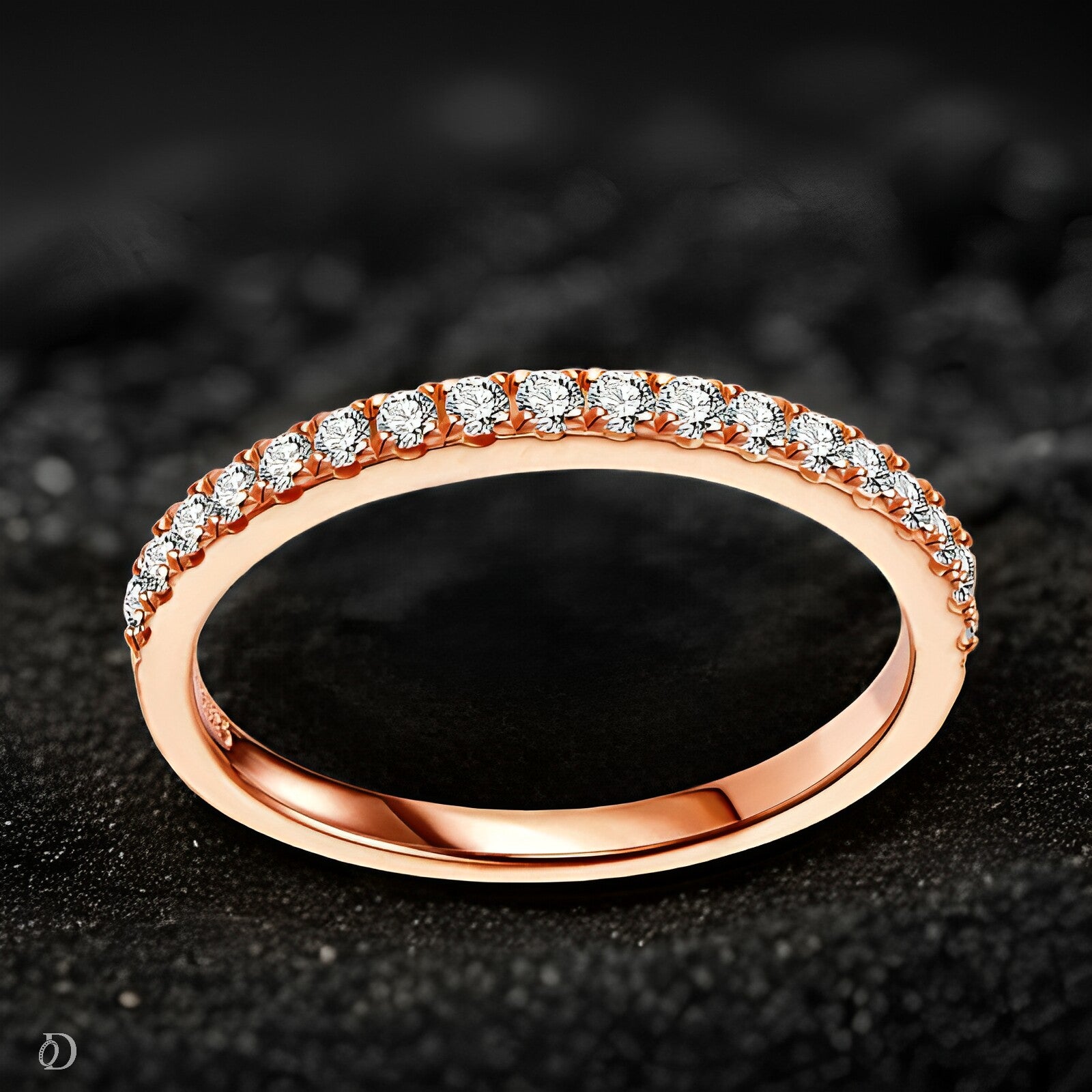 Rose gold ring with diamonds on a dark textured background