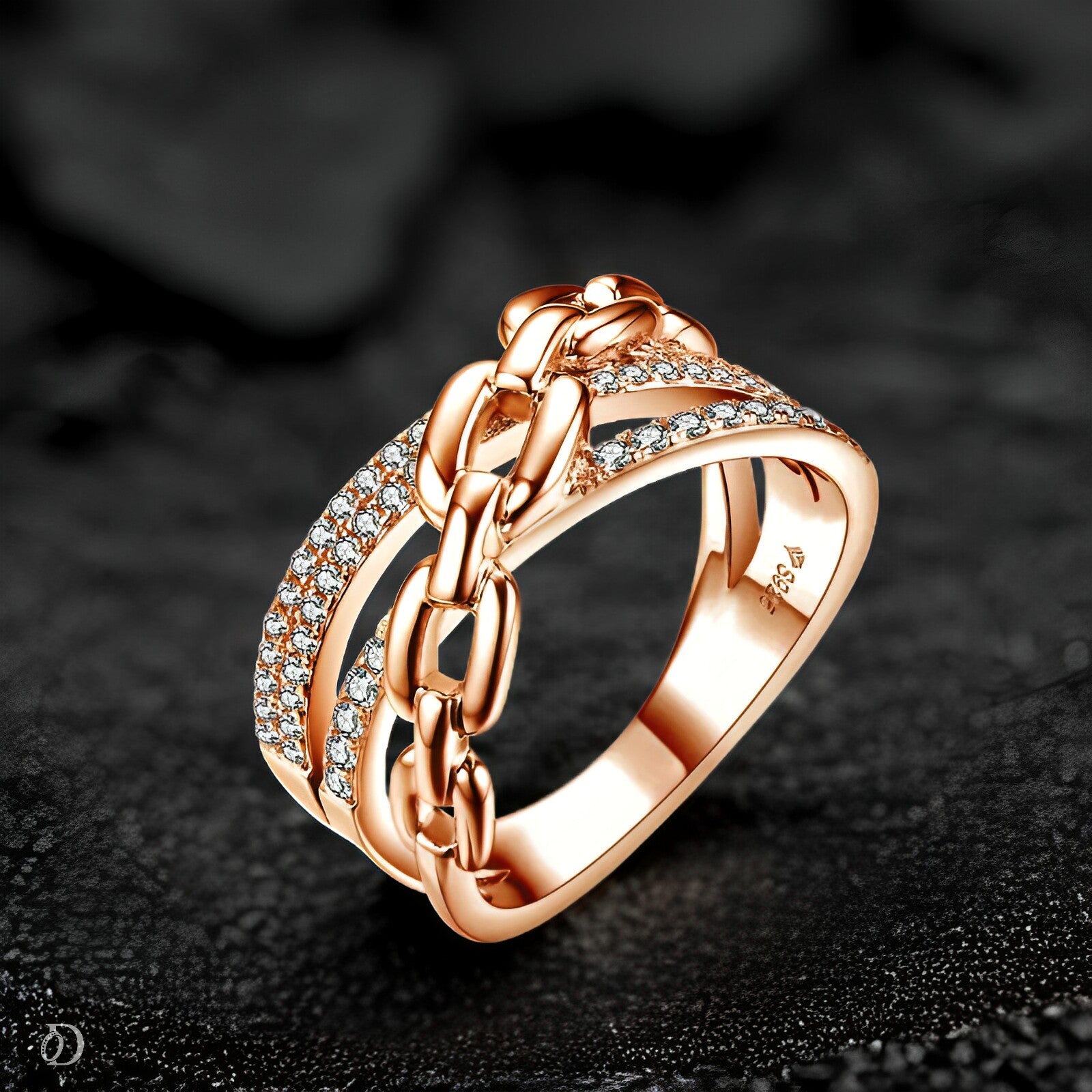 Rose gold ring with chain design and diamond accents on a dark background