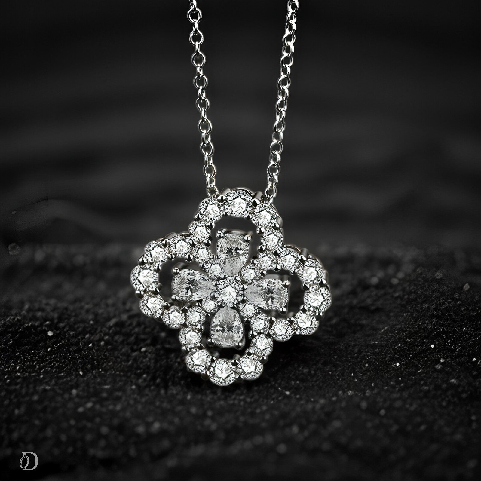 Silver necklace with a decorative pendant featuring D color Moissanite stones on a black textured background