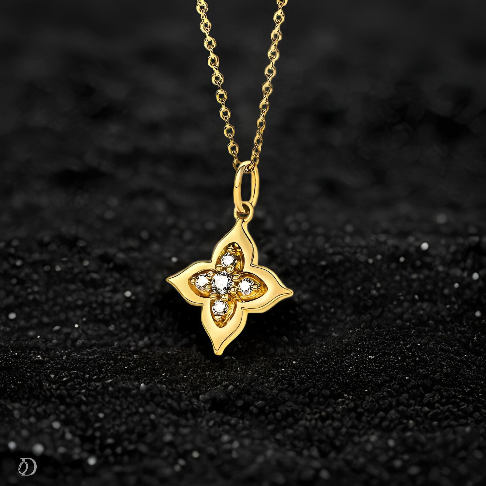 Gold necklace with a clover-shaped pendant on a black textured background