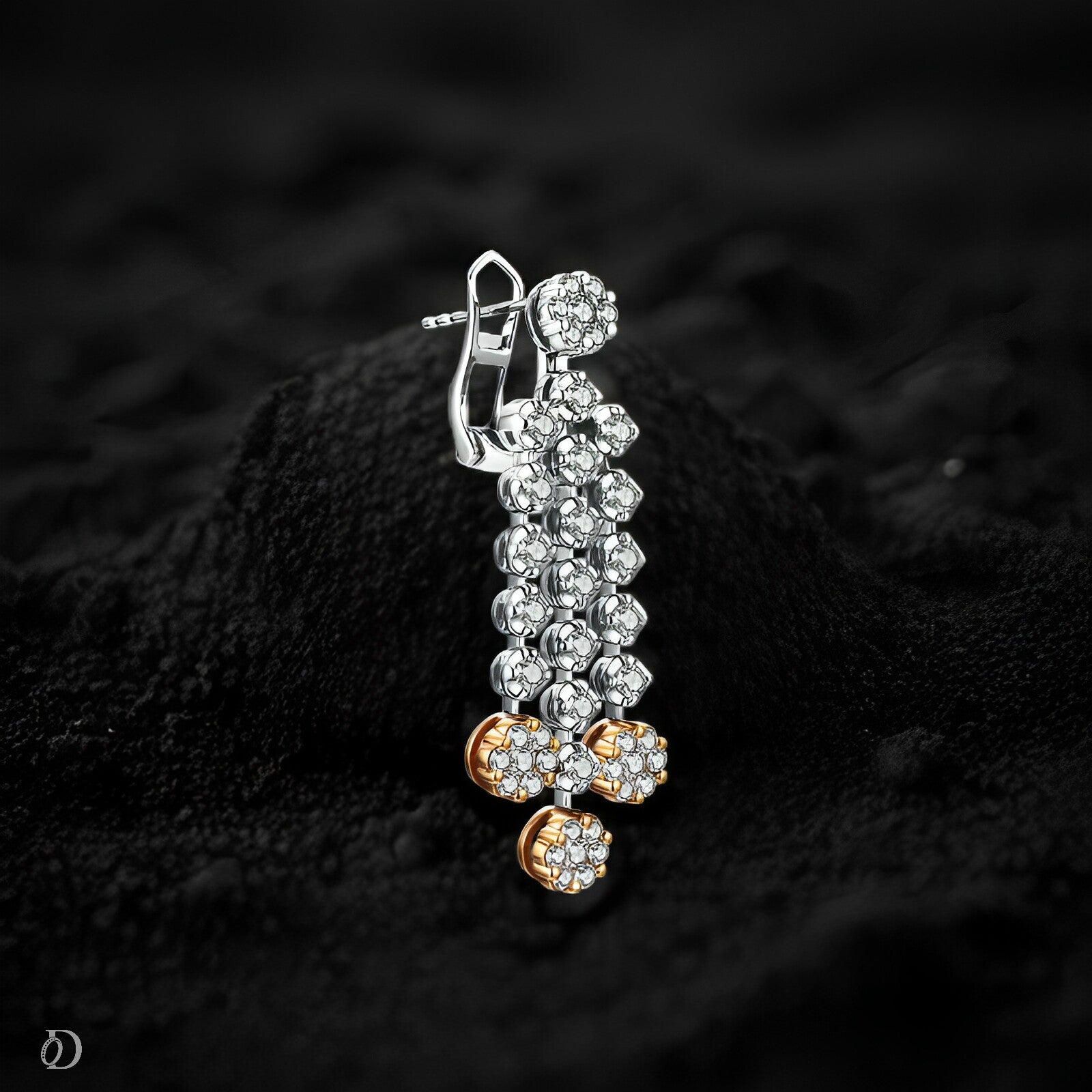 Silver and gold earrings on a black textured background