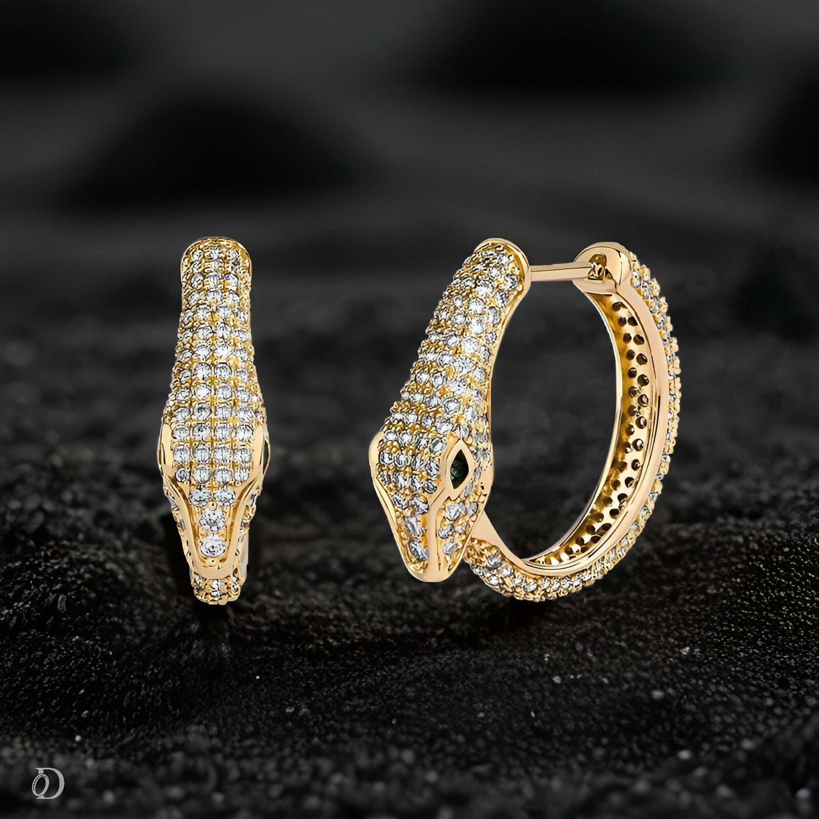 Gold hoop earrings with diamond accents on a black textured background