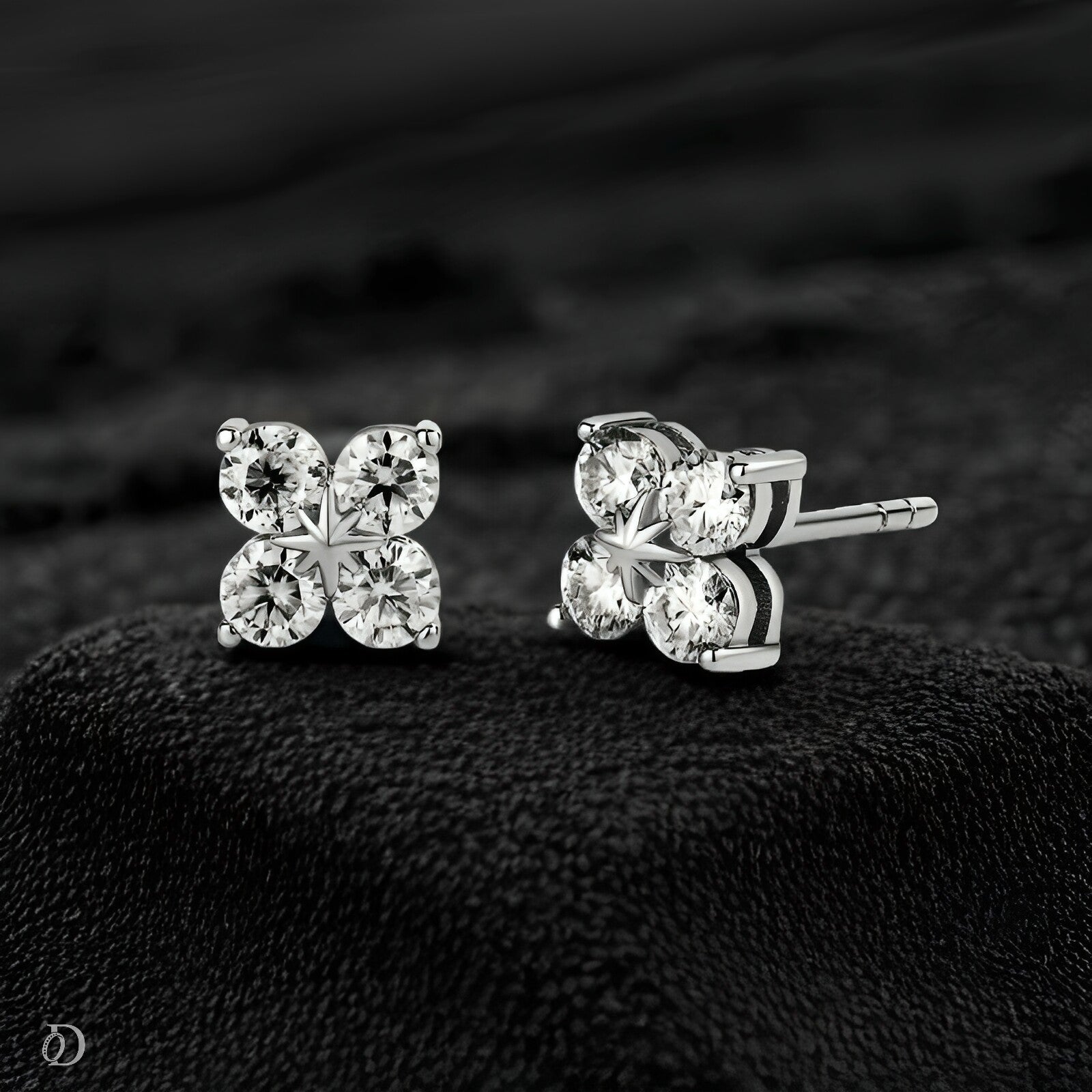 Pair of diamond stud earrings on a black textured surface
