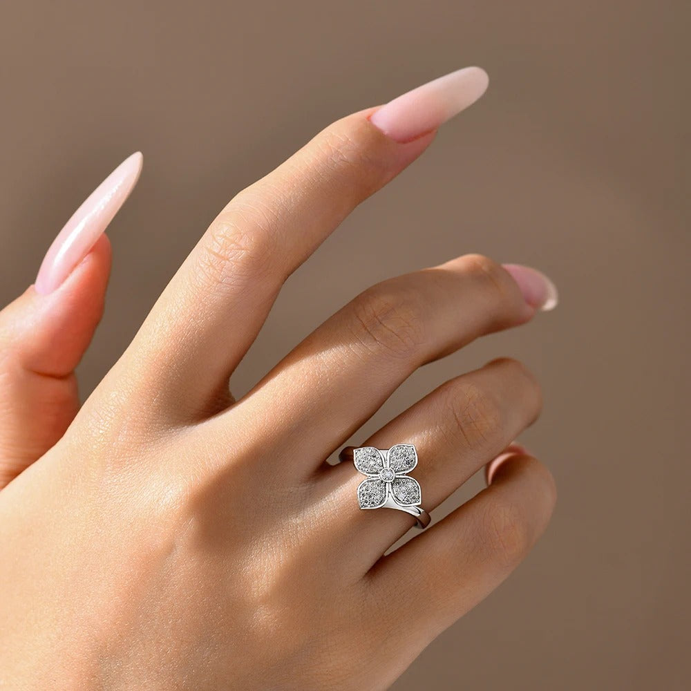Hand wearing a silver butterfly-shaped ring on a neutral background