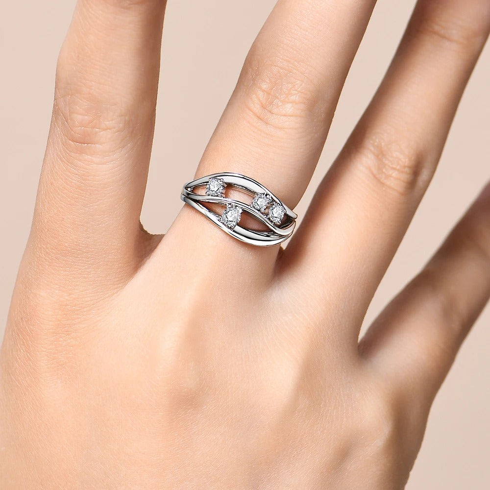 Silver ring with gemstones on a hand against a beige background