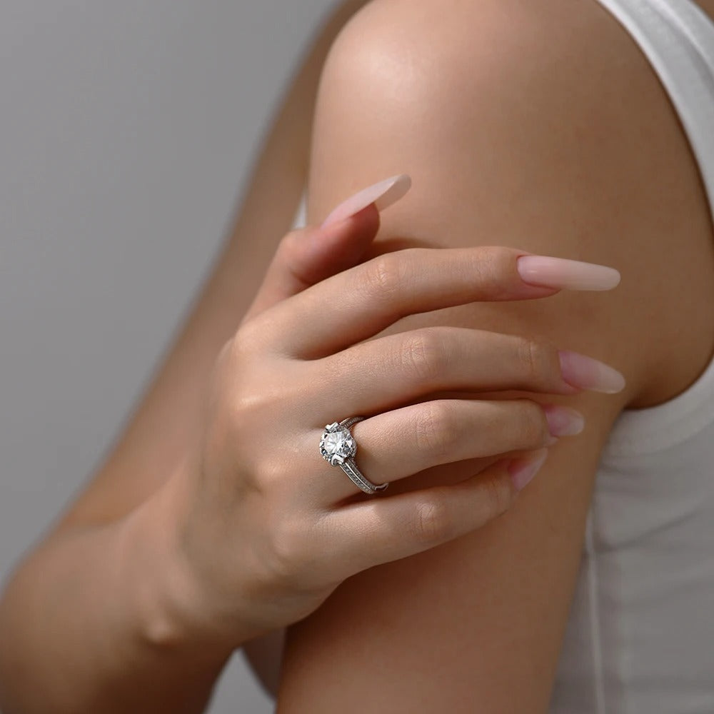 Hand wearing a diamond ring on a neutral background