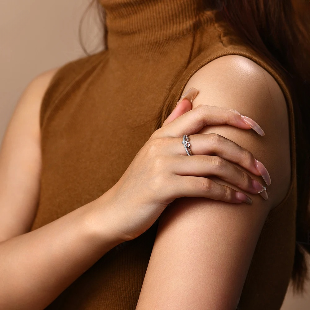 Woman wearing a ring on her finger with a neutral background