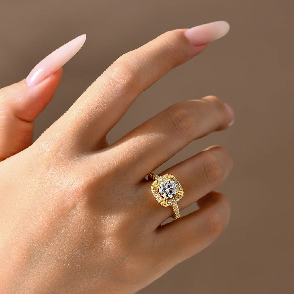 Gold ring with a diamond on a hand against a brown background