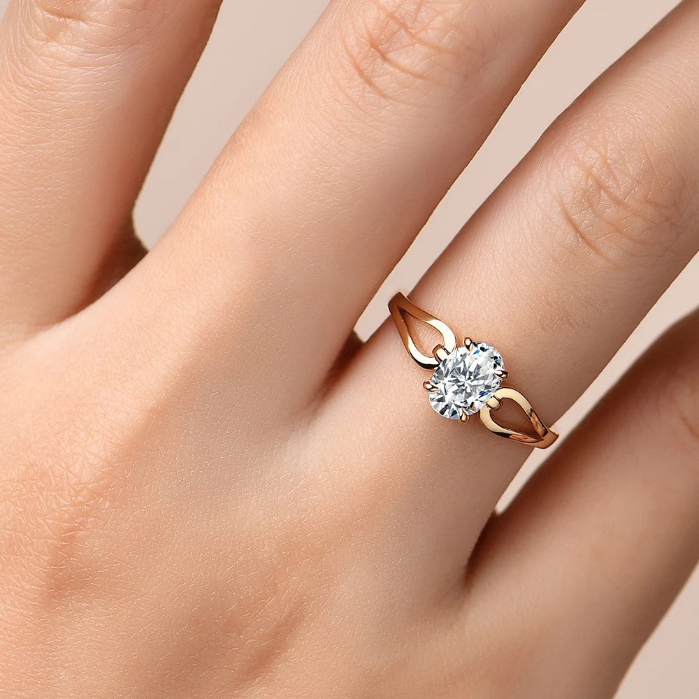 Rose gold ring with a diamond on a hand against a beige background