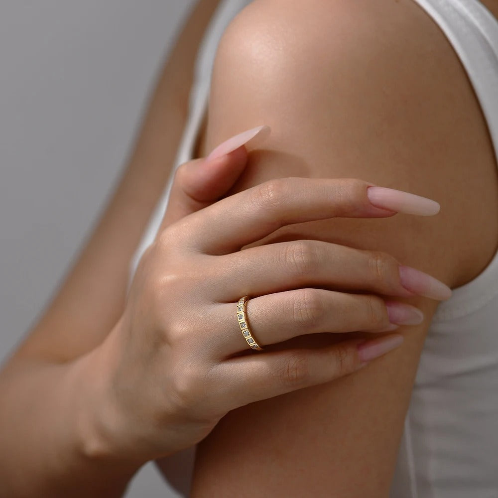 Hand with a gold ring on a light background