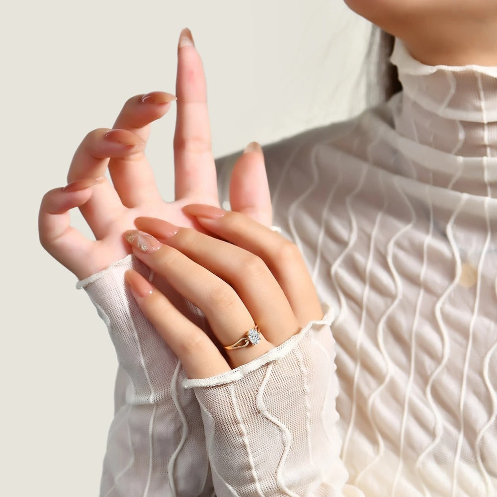 Close-up of a hand wearing a diamond ring with a light background