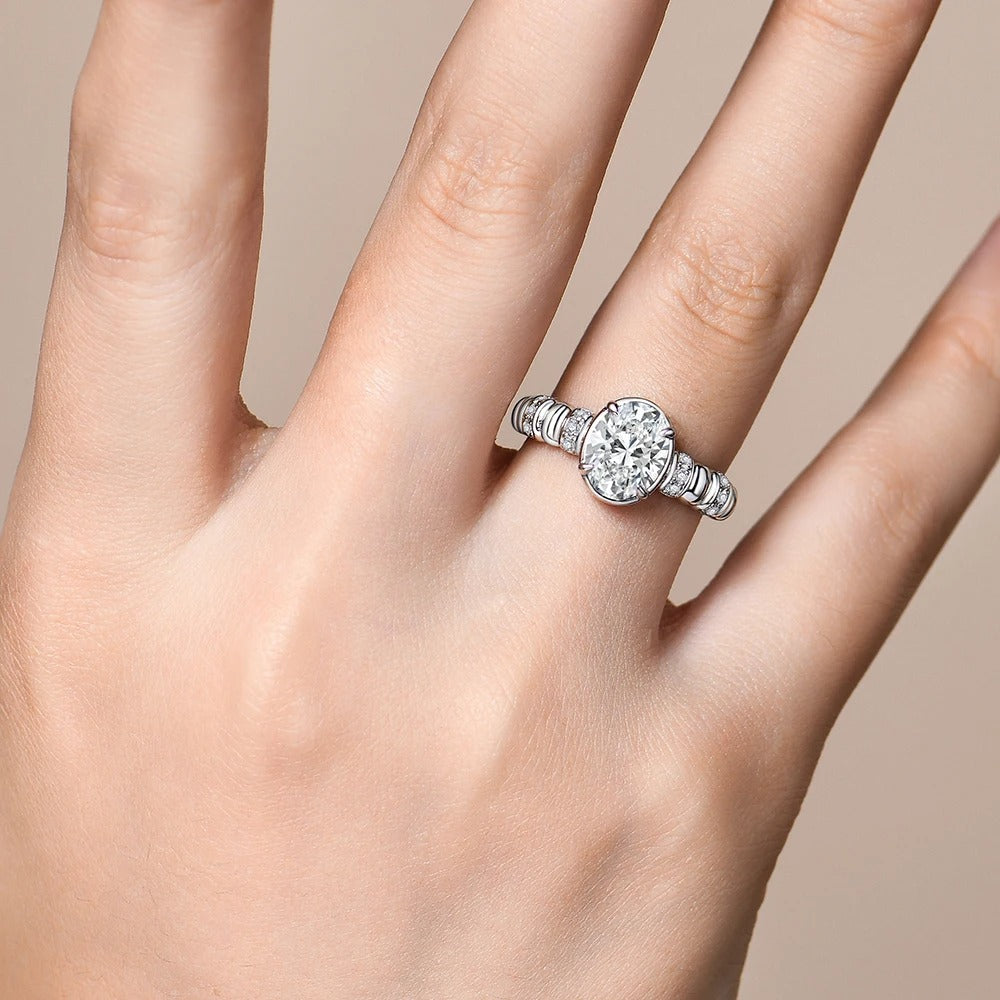 Silver ring with a diamond on a hand against a beige background
