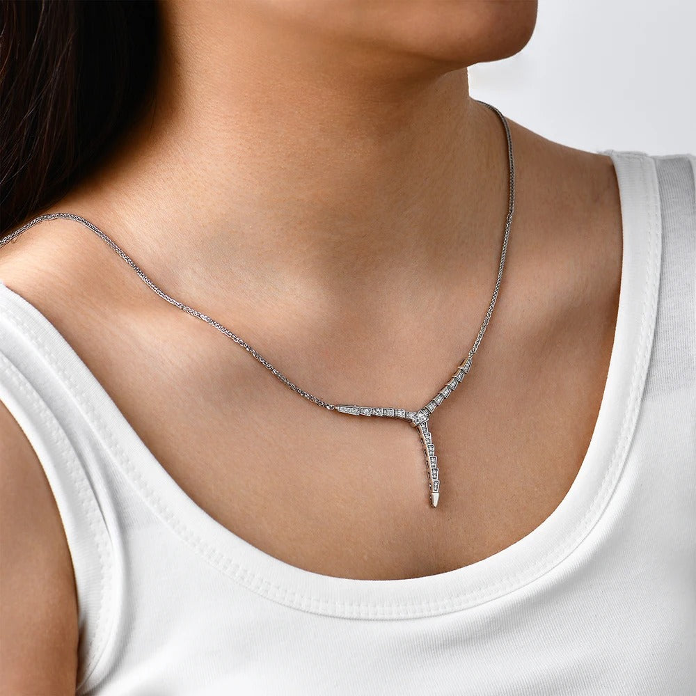 Silver necklace with a pendant on a person wearing a white tank top.
