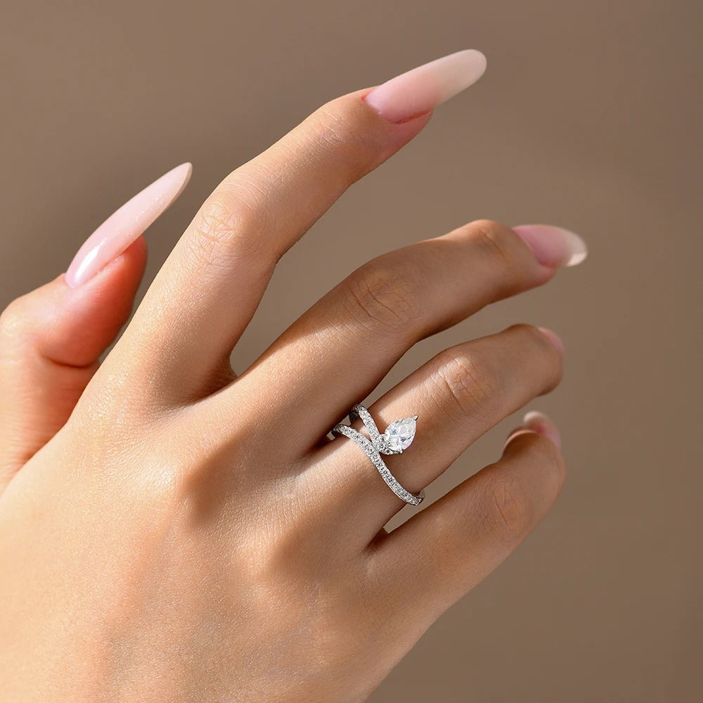 Hand wearing a diamond ring on a neutral background