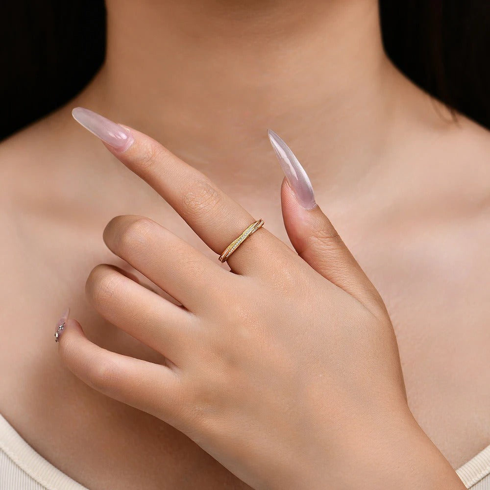 Close-up of a hand wearing a gold ring with a blurred background
