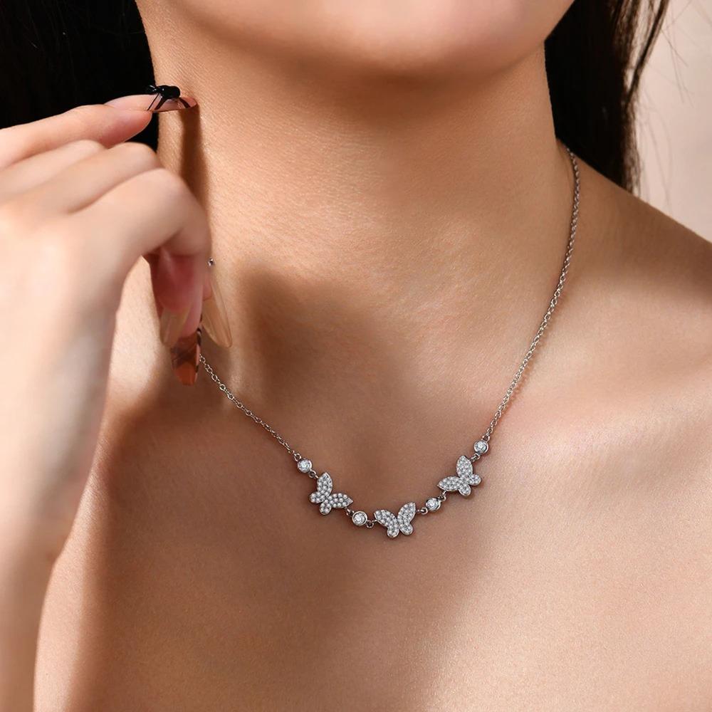 Butterfly necklace on a person's neck with a blurred background