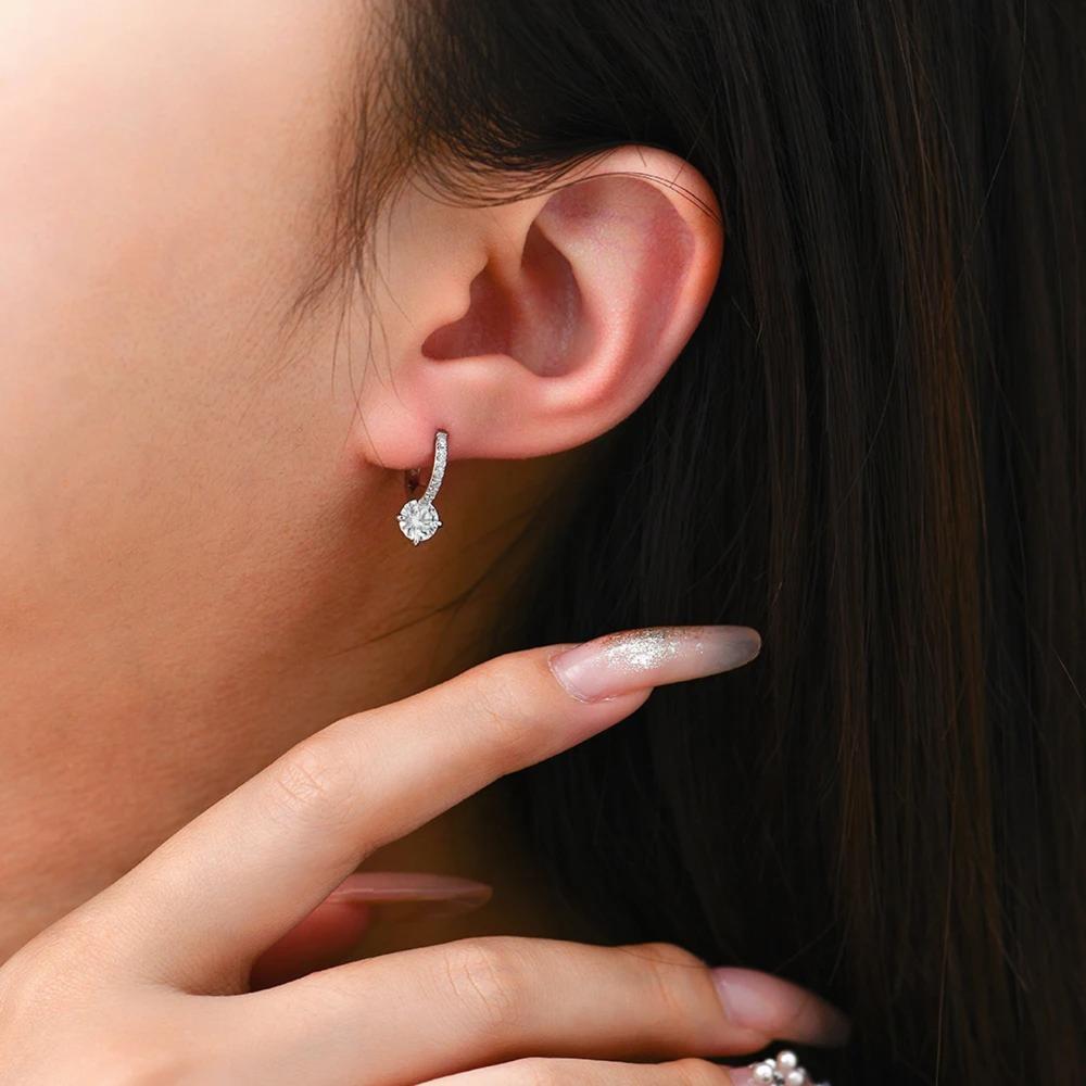 Close-up of a person wearing a diamond earring with a blurred background