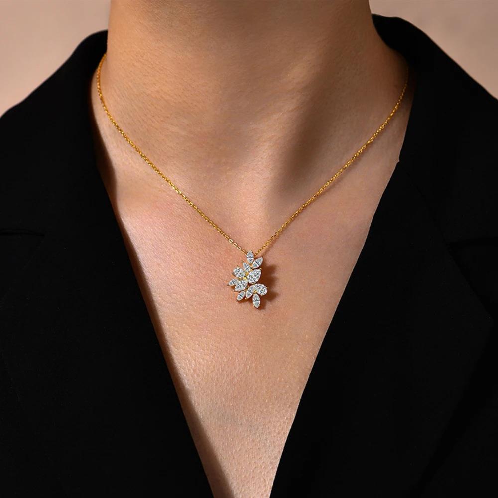 Gold necklace with a diamond pendant worn by a person against a black background