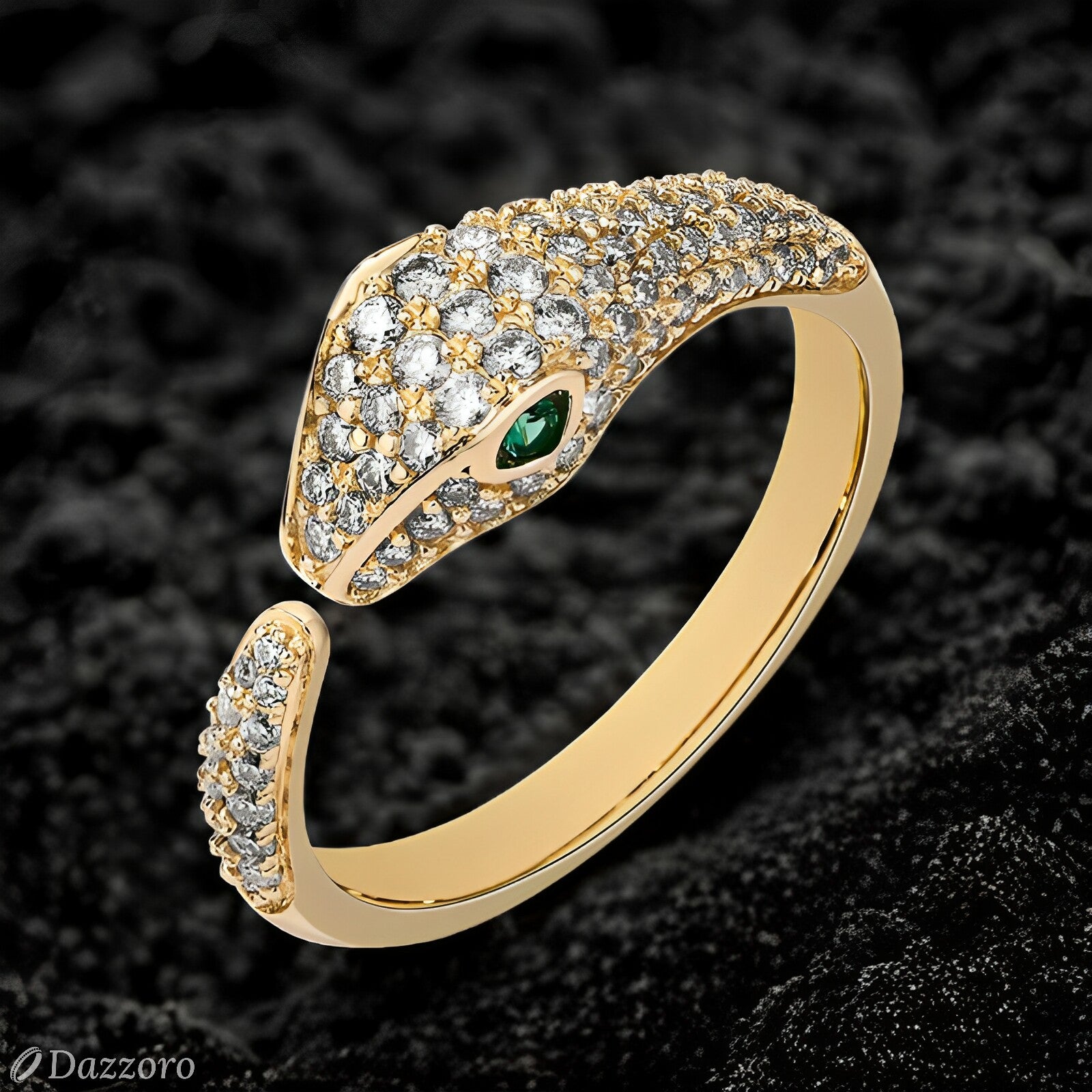 Gold snake-shaped ring with diamond accents and a green gemstone on a dark textured background.