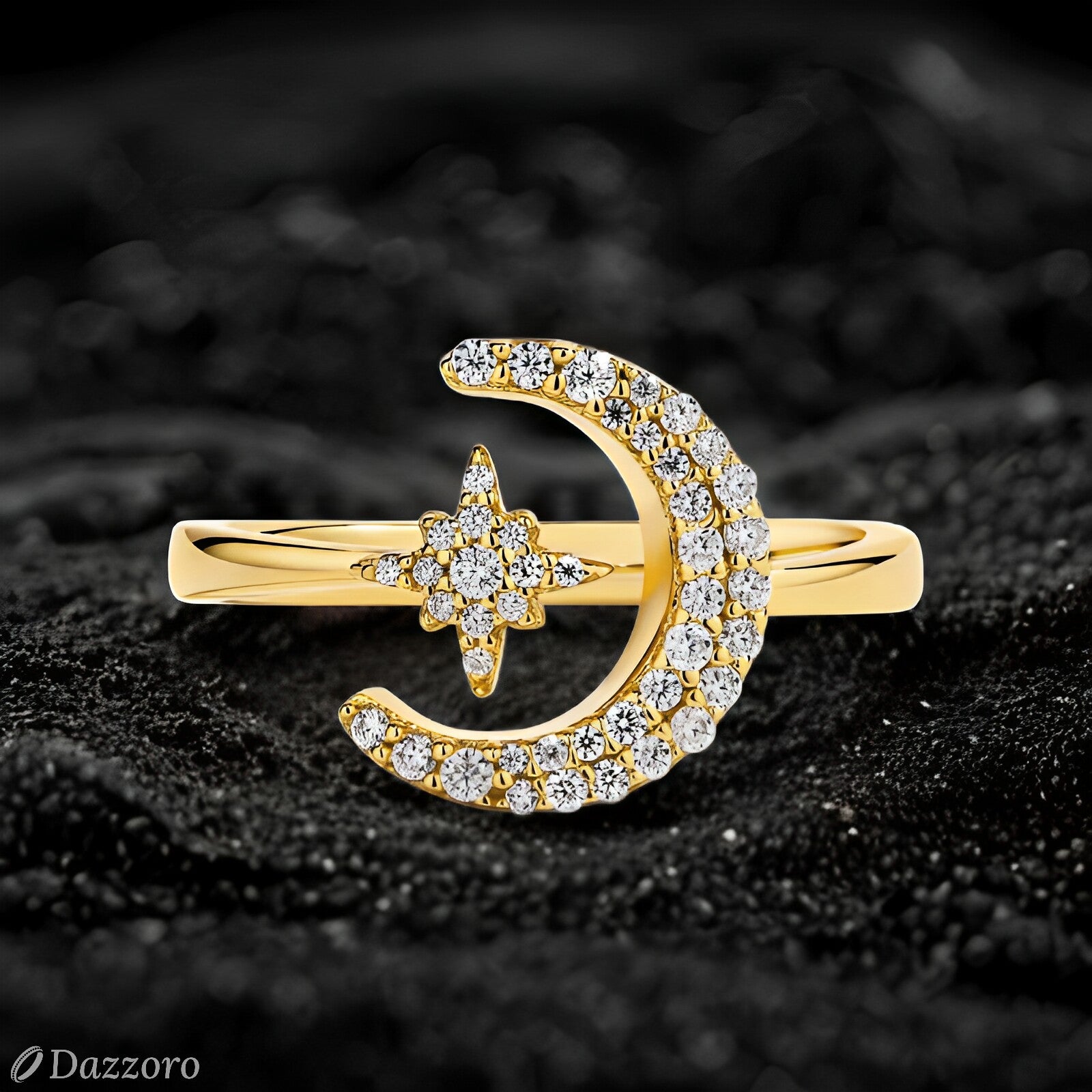 Gold ring with moon and star design on a black textured background, Dazzzoro brand visible.
