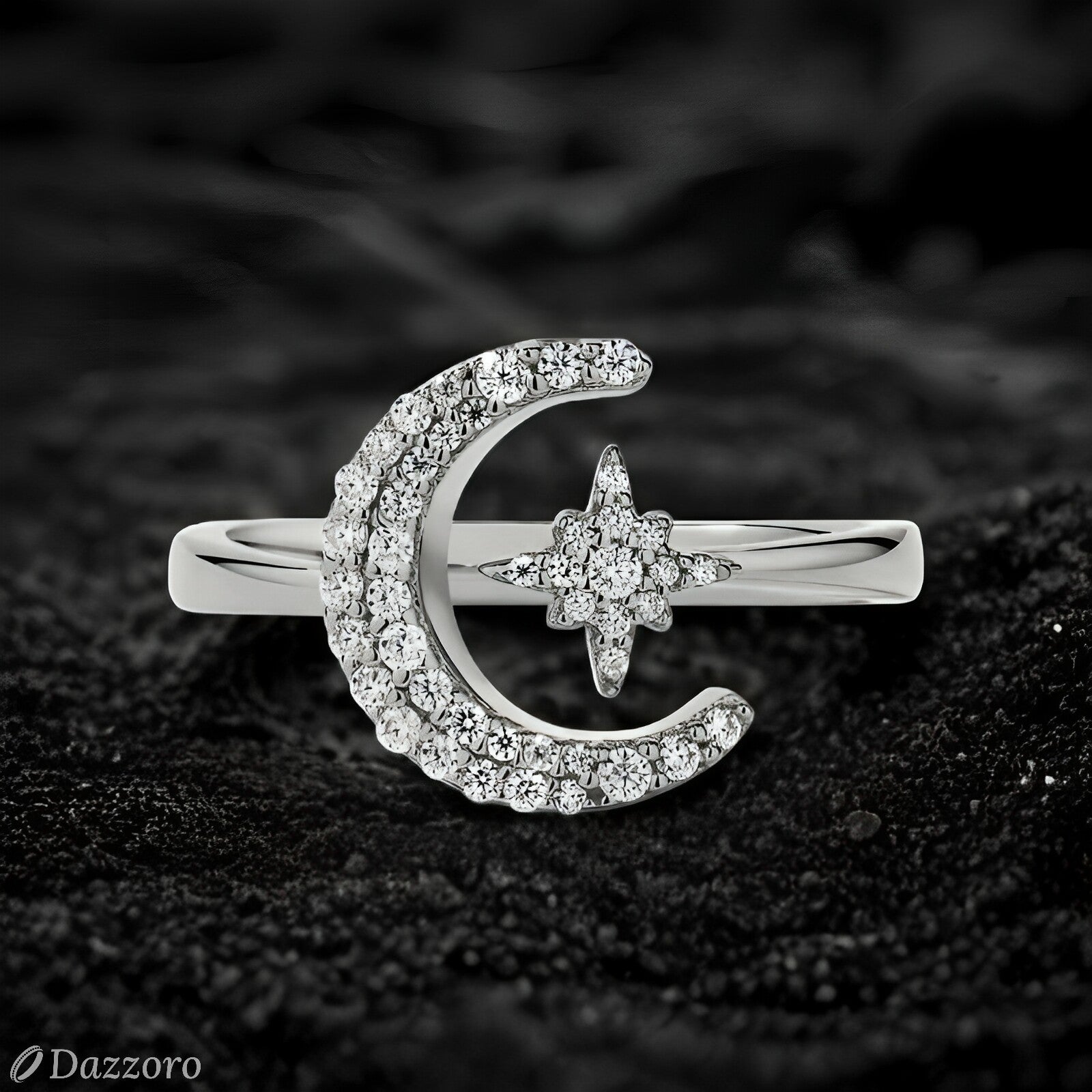 Silver ring with moon and star design on a dark textured background, branded 'Dazzzoro'.