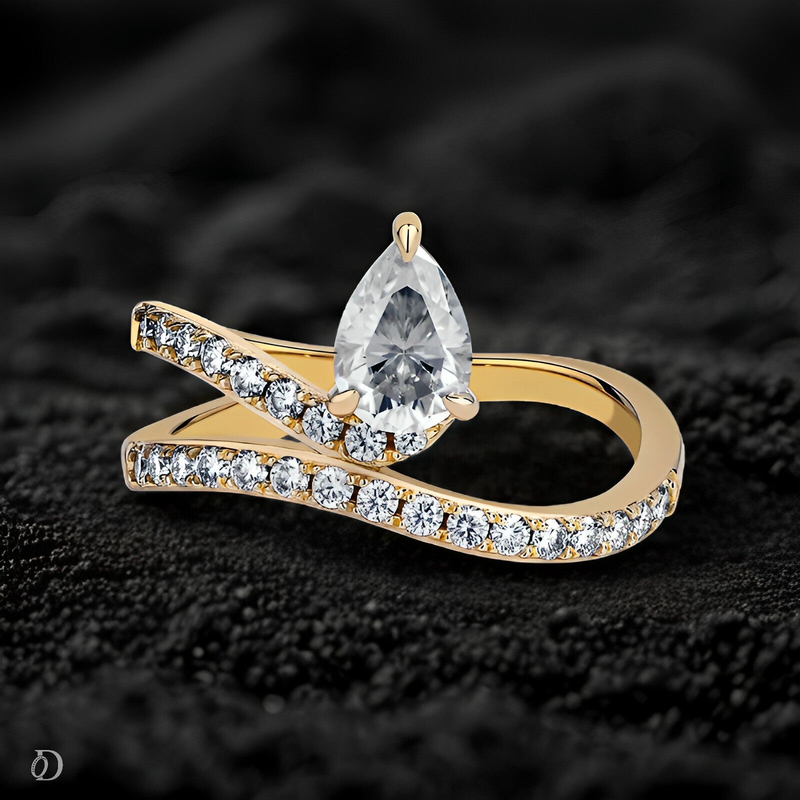 Gold ring with a pear-shaped diamond on a dark textured background