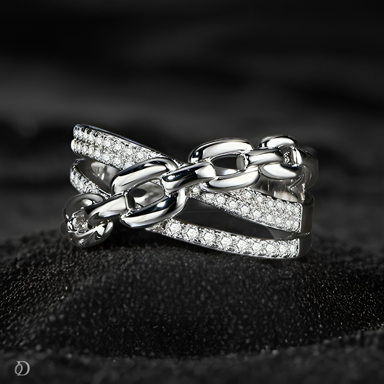 Silver chain and bow ring on a dark textured surface