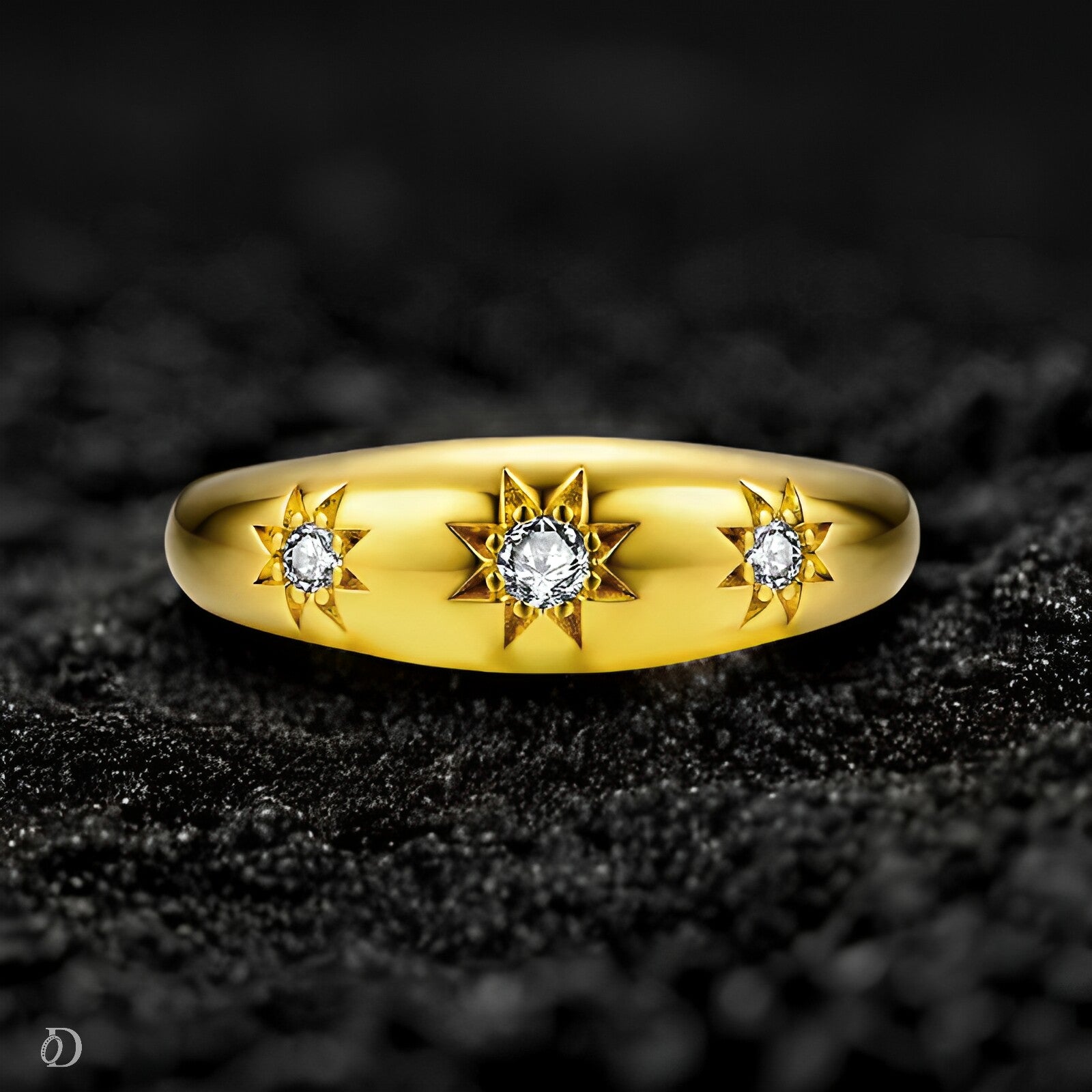 Gold ring with star designs and diamonds on a black textured background