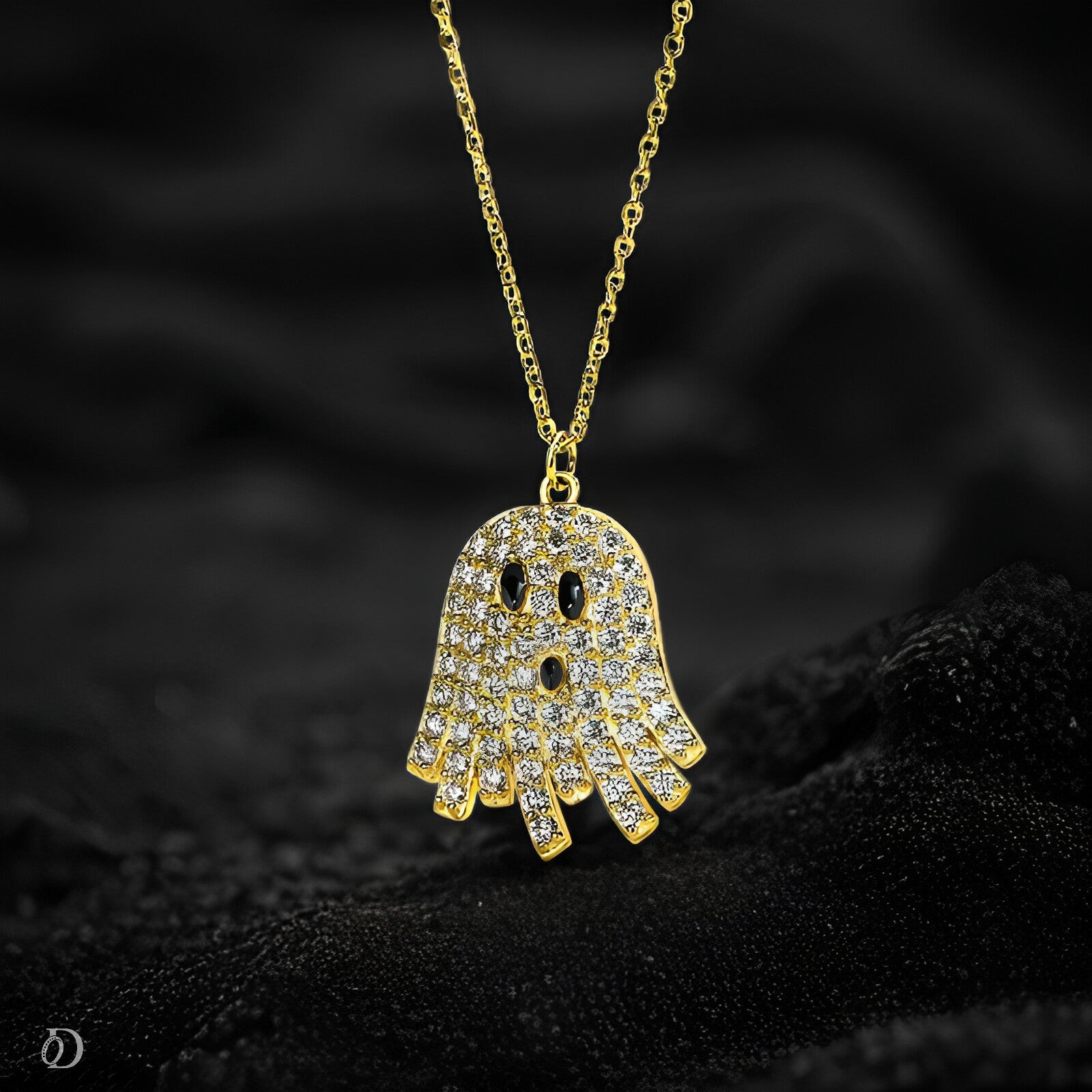 Gold ghost-shaped pendant necklace on a dark textured background