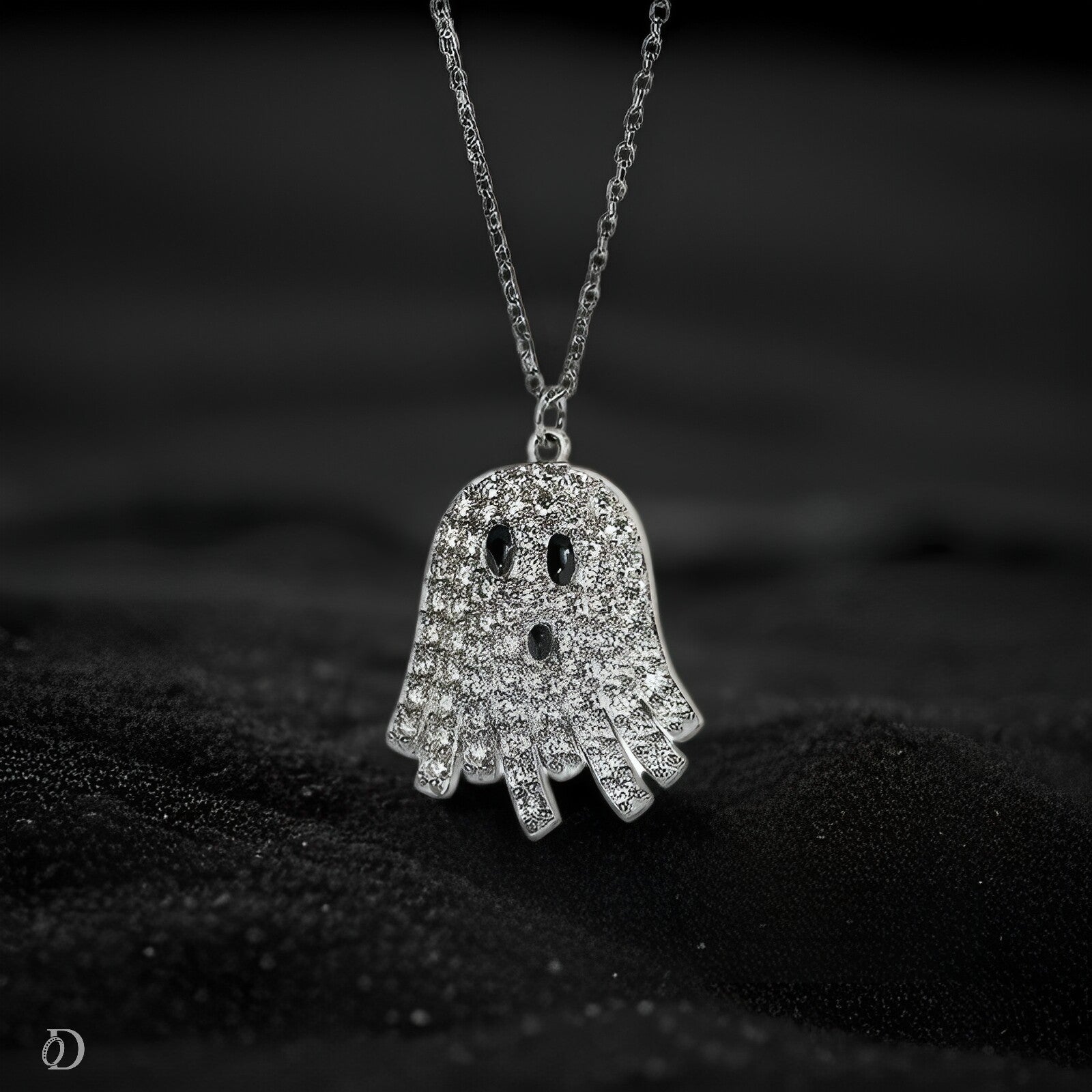 Silver ghost-shaped pendant necklace on a dark background