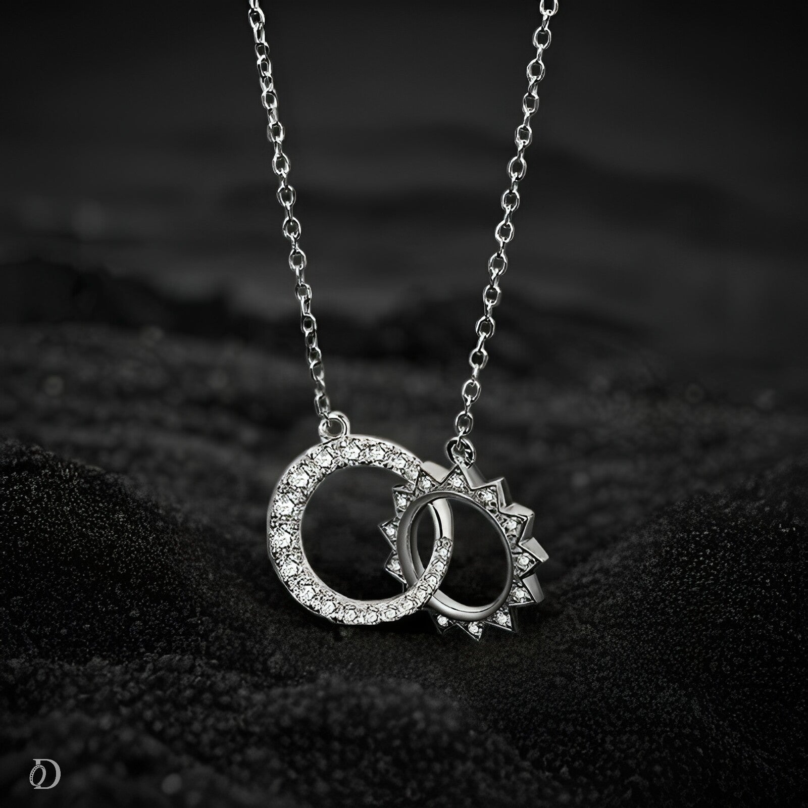 Silver necklace with interlocking rings pendant on a dark textured background