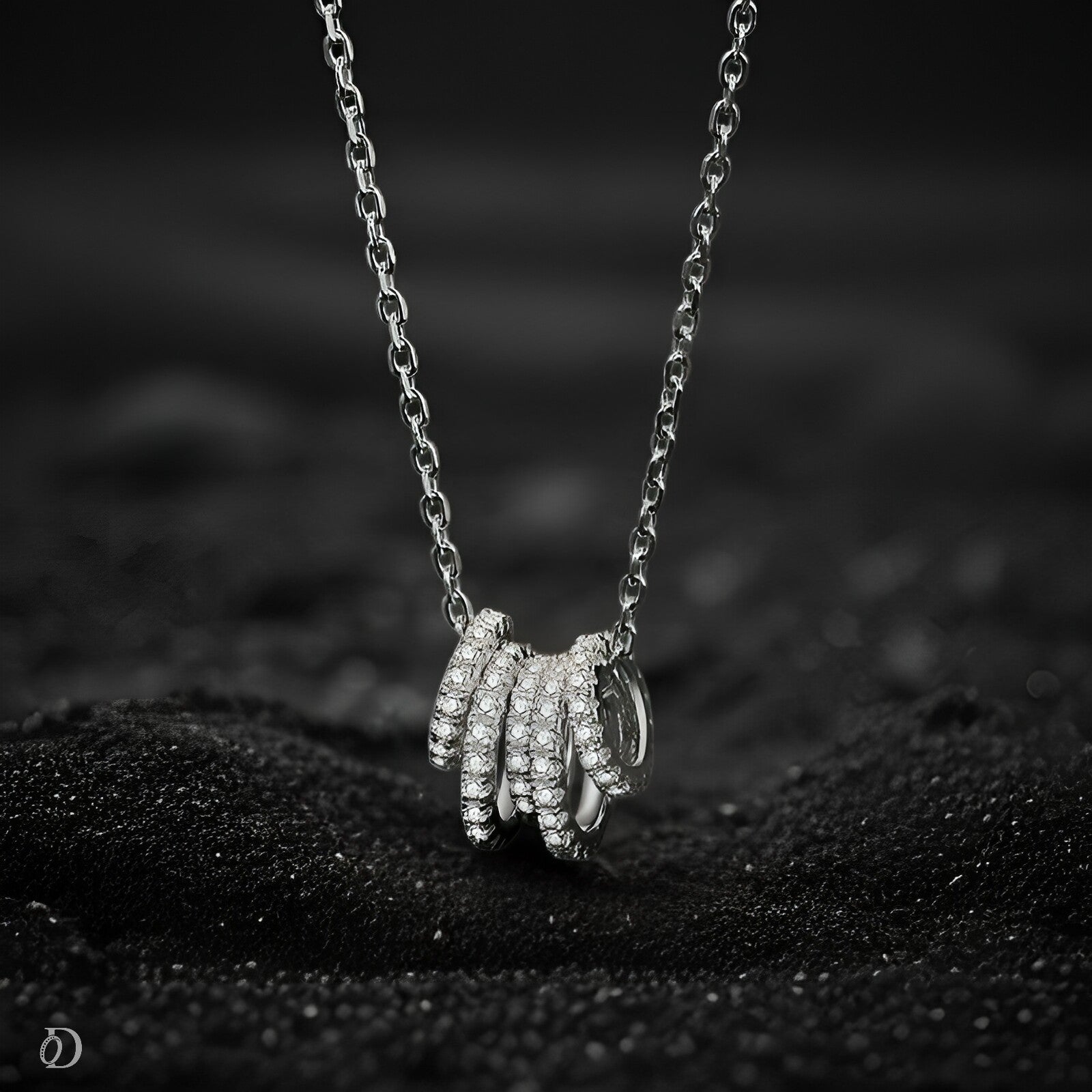 Silver necklace with a unique pendant on a black textured surface