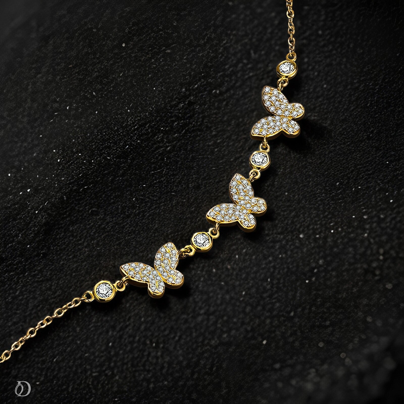 Gold butterfly necklace with clear stones on a black background