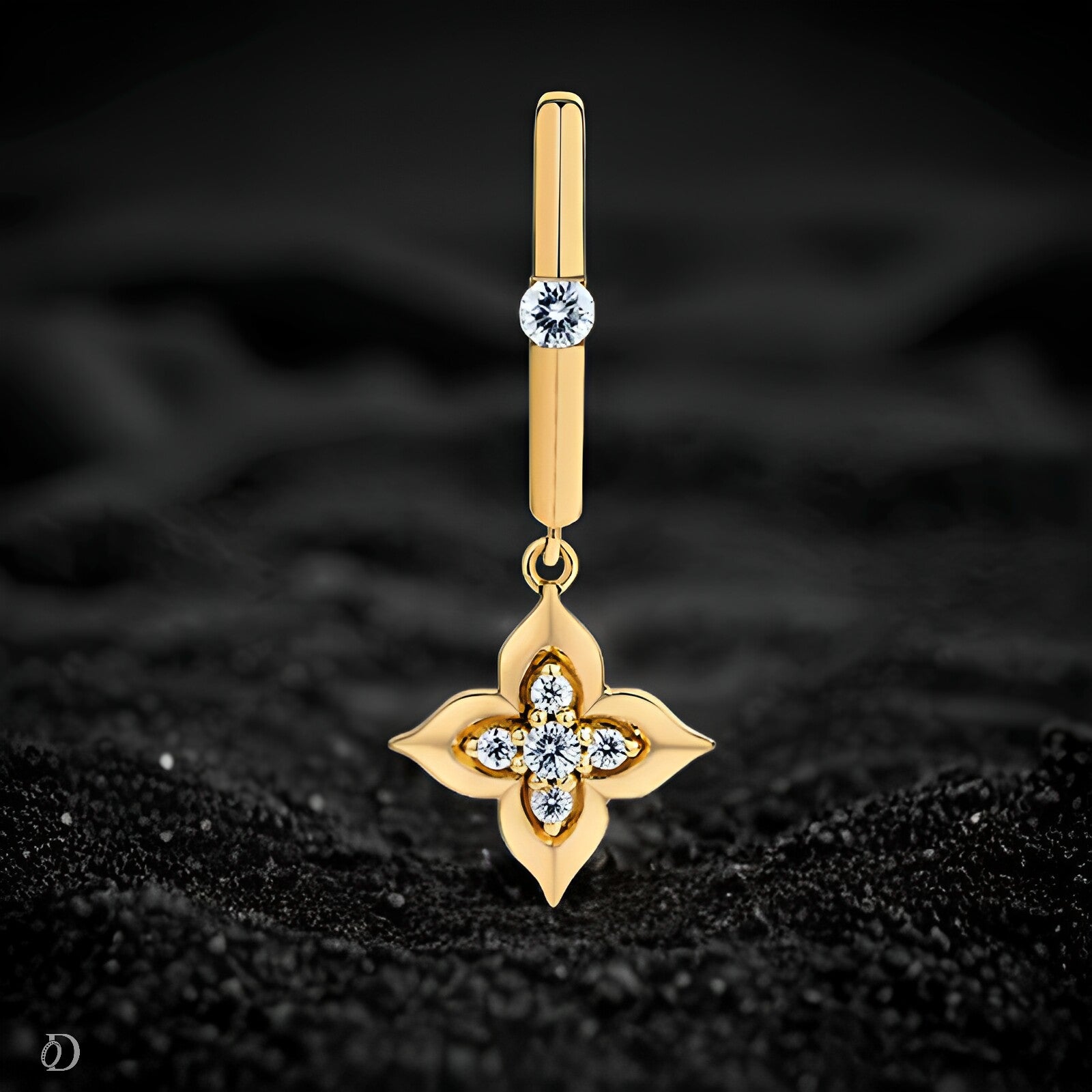 Gold earring with floral design and embedded stones on a black textured background