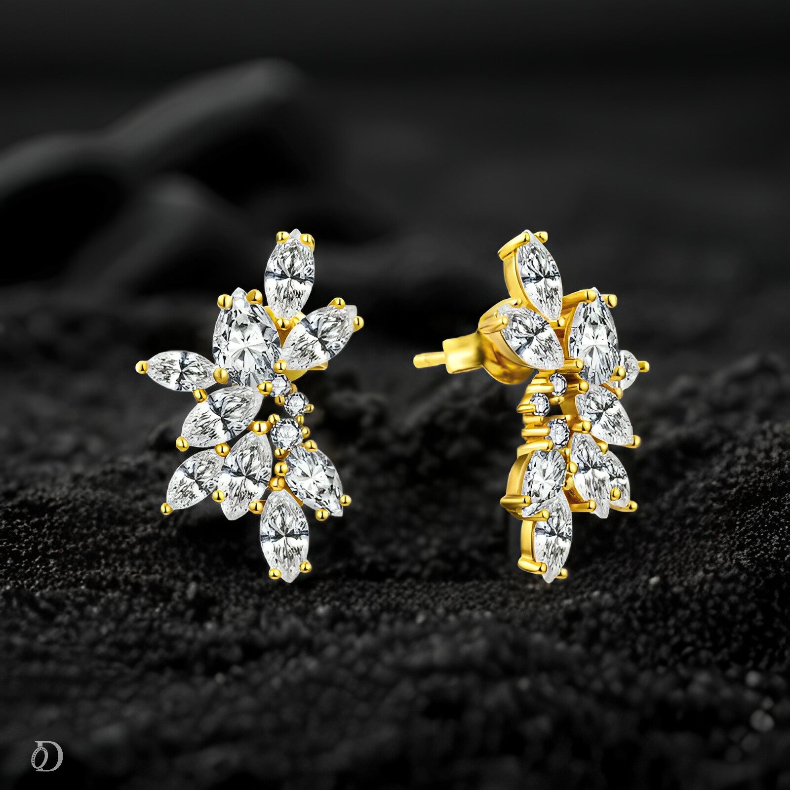 Gold and diamond earrings on a dark textured background