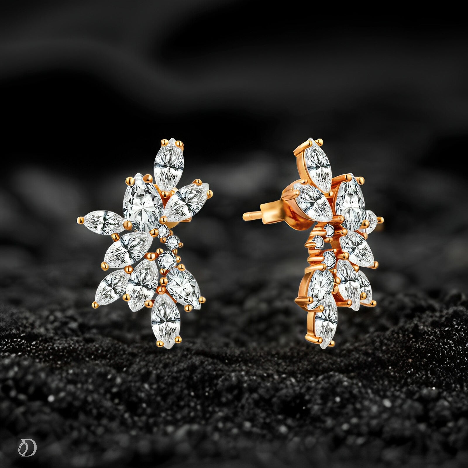 Pair of gold and diamond earrings on a black textured background