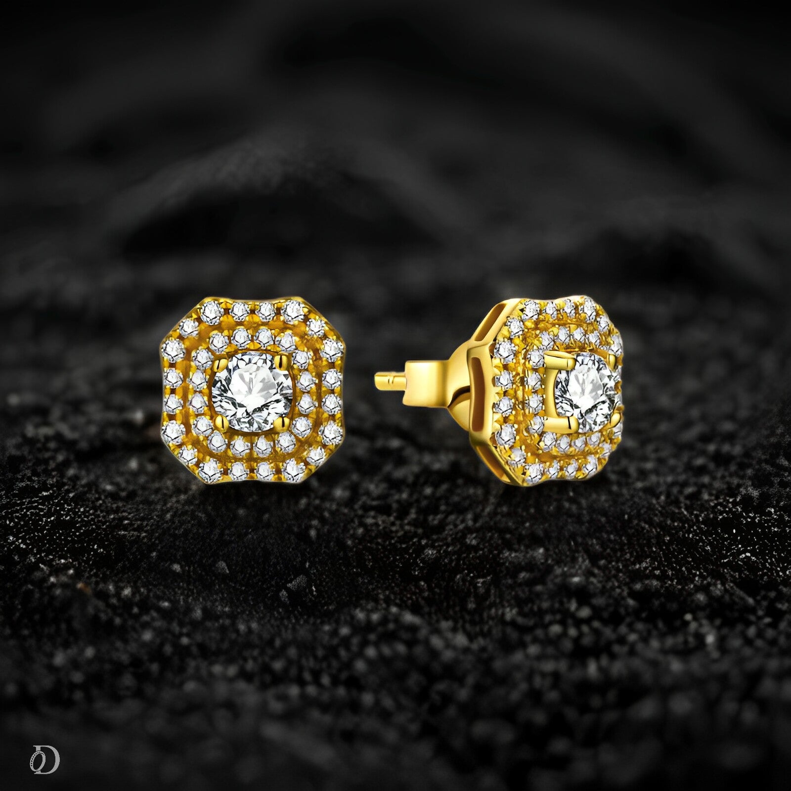 Gold earrings with clear gemstones on a dark textured background