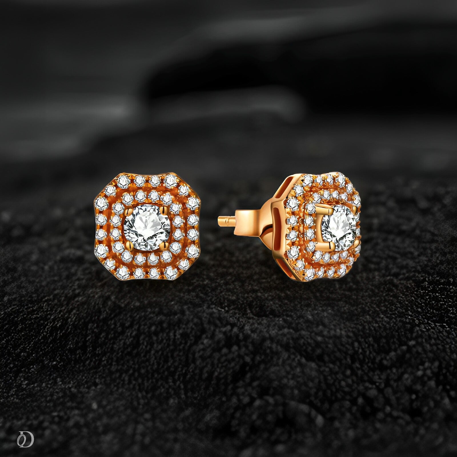 Pair of gold earrings with diamond accents on a dark textured background