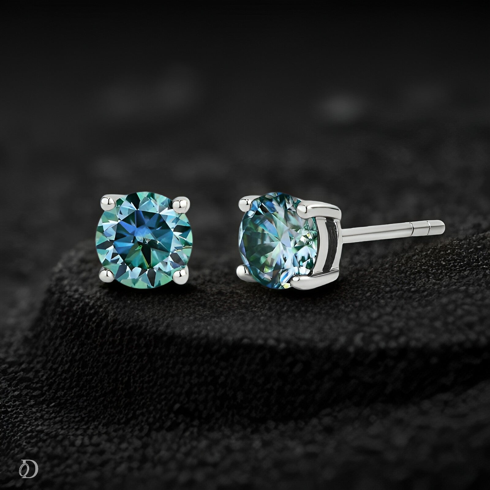 Pair of teal gemstone stud earrings on a dark textured background