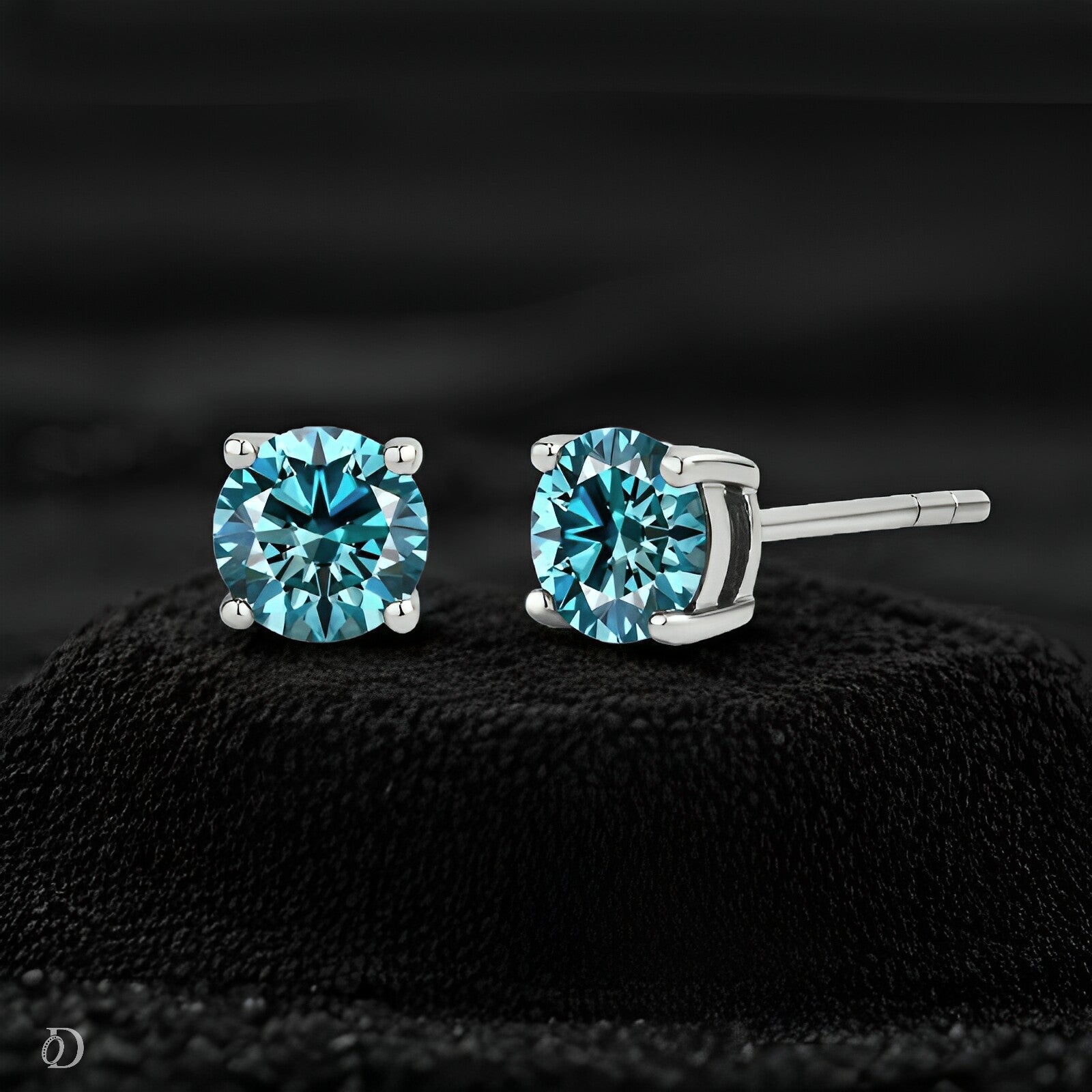 Pair of blue gemstone stud earrings on a black textured background