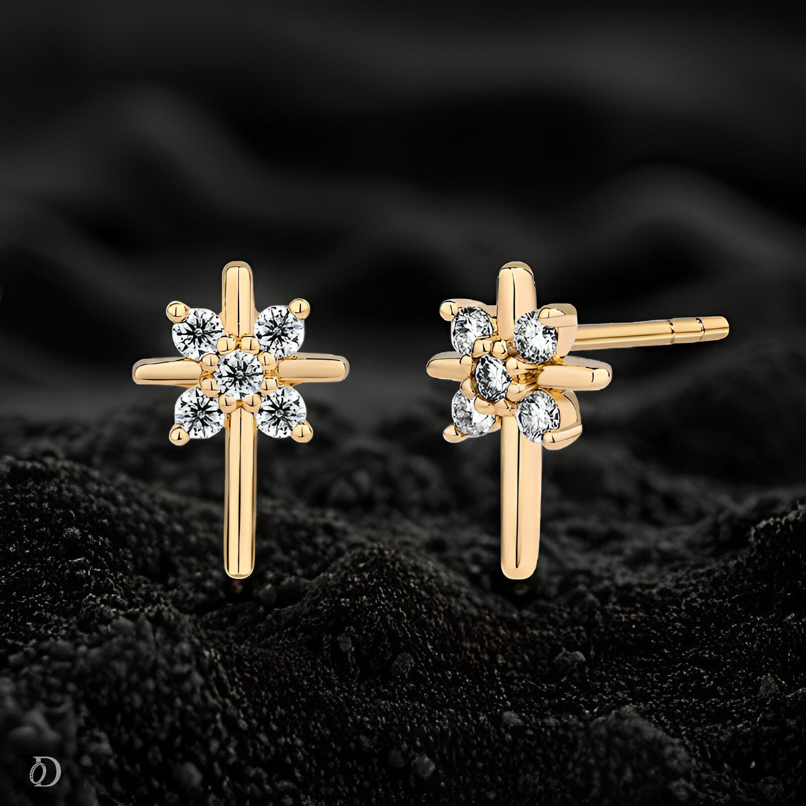 Gold earrings with diamond-like stones on a black textured background