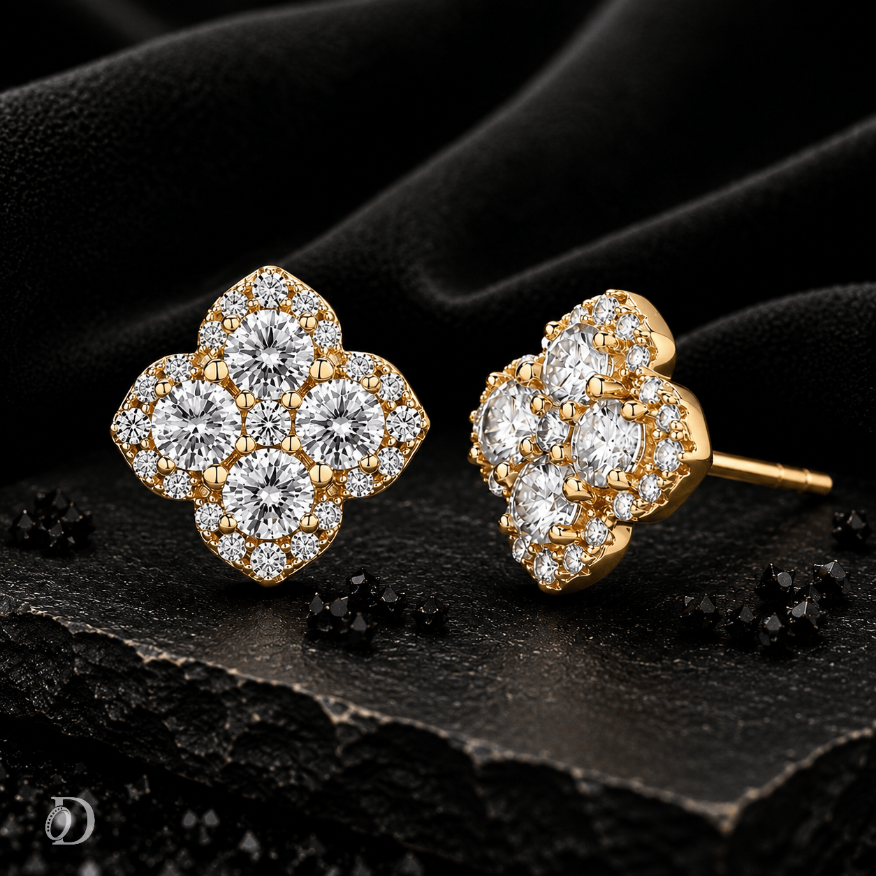 A pair of gold-toned stud earrings with clustered round-cut clear stones, shown on a dark textured surface with black fabric in the background.