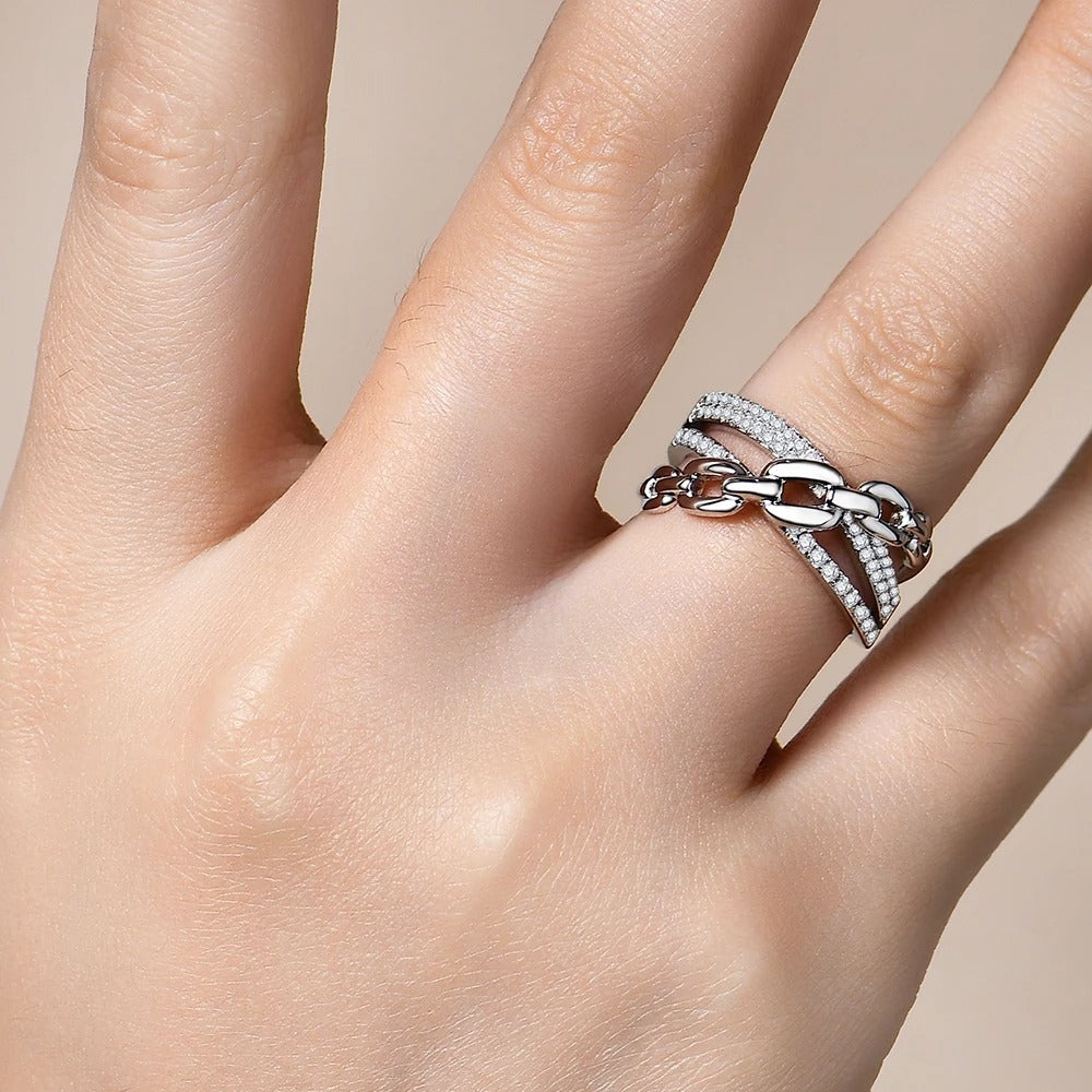 Close-up of a hand wearing a silver ring on a neutral background